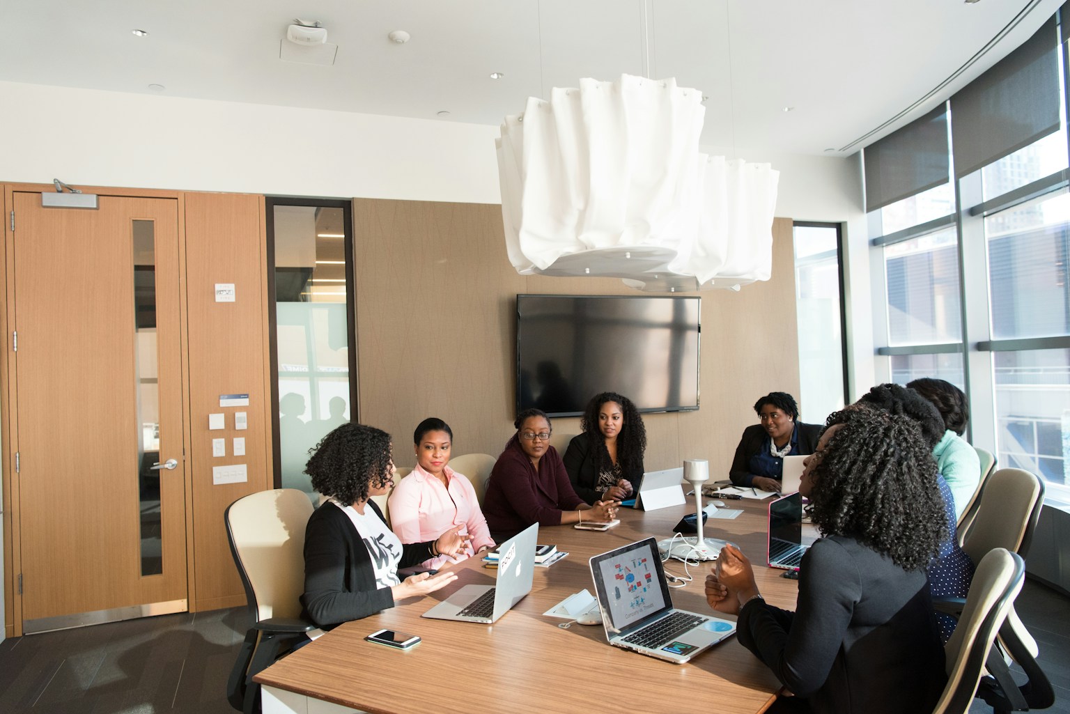 Black woman financial advisor consulting with a client in a modern office